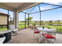Relaxing screened lanai with brick flooring, outdoor furniture, and stunning lake view at 16127 Fortezza Dr, Bradenton, FL 34211
