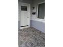 Front door on stone-paved landing with modern wall fixtures and exterior paint scheme at 2098 35Th N St, St Petersburg, FL 33713