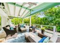 Covered patio featuring comfortable seating, ceiling fans, and views of the lush tropical backyard at 213 84Th St, Holmes Beach, FL 34217
