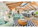 Open-concept living room with vaulted ceiling, exposed beams, and stylish decor with view to kitchen at 213 84Th St, Holmes Beach, FL 34217