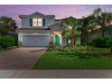 Inviting home exterior showcases professional landscaping, complemented by the warmth of the home's architectural details and lighting at 3409 Anchor Bay Trl, Lakewood Ranch, FL 34211