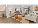Bright living room with wood floors, a large TV, modern furniture, and sliding glass doors for indoor-outdoor living at 3409 Anchor Bay Trl, Lakewood Ranch, FL 34211