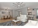 Open-concept living room with neutral decor, tile floors, and access to the dining area and kitchen for easy entertaining at 8402 Grand Estuary Trl # 101, Bradenton, FL 34212