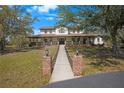 Charming two-story home featuring a welcoming front porch and well-maintained landscaping at 12001 Backwater Rd, Sarasota, FL 34240