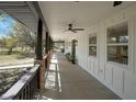 Inviting porch with black railings, brick pillars, fans, and exterior lights at 12001 Backwater Rd, Sarasota, FL 34240