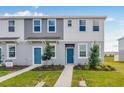 Charming two-story townhomes with blue front doors, well-manicured lawns, and vibrant green space at 16606 San Nicola Pl, Lakewood Ranch, FL 34211