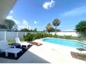 Outdoor pool area featuring lounge chairs and well-maintained landscaping and a clear blue sky at 241 Seminole Nw Blvd, Port Charlotte, FL 33952