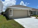 Two-car garage with neutral door, exterior lanterns, and freshly poured driveway, offering ample parking at 2648 Averland Loop, North Port, FL 34287