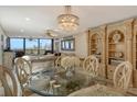Elegant dining area with a chandelier and built-in shelving at 5740 Midnight Pass Rd # 307, Sarasota, FL 34242