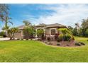 Well-maintained property with vibrant landscaping, mature palm trees, and a neatly manicured lawn, creating an inviting entrance at 3826 E 155Th E Ave, Parrish, FL 34219