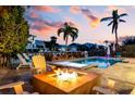 Inviting outdoor space with a fire pit, spa, pool, and lush landscaping, ideal for entertaining at 718 Key Royale Dr, Holmes Beach, FL 34217