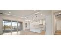 Bright kitchen features white cabinetry, stainless appliances, and a large center island with view to the water at 8528 Beechlake Ct, Sarasota, FL 34240