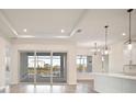 Bright open-concept living room with sliding glass doors and an island with pendant lighting at 8528 Beechlake Ct, Sarasota, FL 34240