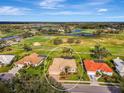 Expansive aerial shot showcasing a tile roof home situated on a golf course community with ponds at 124 Ventana Way, Venice, FL 34292