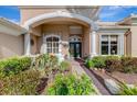 Charming home entrance with elegant columns, decorative windows, and well-maintained landscaping at 124 Ventana Way, Venice, FL 34292