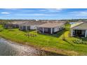 Beautiful backyard with lush lawn and a screened-in patio perfect for relaxing by the water at 25532 Royal Tern Ln, Englewood, FL 34223