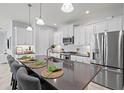 Modern kitchen featuring a large island with seating, stainless steel appliances, and white cabinets at 2722 Sapphire Blue Ln, Bradenton, FL 34211