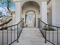 Inviting front entrance with stone steps, wrought iron railings, and an arched doorway creating an elegant approach at 3540 Bayou Cir, Longboat Key, FL 34228