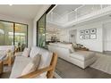 An open concept living room with a white railing, view of the kitchen, and neutral colored furnishings at 4886 Seafoam Trl, Bradenton, FL 34211