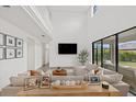 Bright living room with soaring ceilings, neutral tones, and large sliding glass doors to a private backyard at 4886 Seafoam Trl, Bradenton, FL 34211