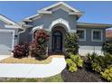 Charming home featuring a decorative archway leading to a beautiful front door and nicely landscaped yard at 5383 Creekside Trl, Sarasota, FL 34243