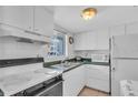 Kitchen with white cabinets, green countertops, and essential appliances at 5889 Canal Dr # I4, Bradenton, FL 34207