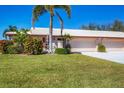 Charming home with lush green lawn, mature landscaping, and a two-car garage at 6420 13Th Avenue W Dr, Bradenton, FL 34209