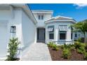 Inviting front entrance with a paved walkway, stylish exterior lighting, and freshly planted landscaping at 8024 Moonbeam Ave, Sarasota, FL 34241