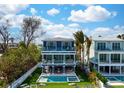 Stunning three-story home with a pool, jacuzzi, and a scenic ocean view from multiple levels at 915 N Shore Dr, Anna Maria, FL 34216