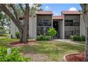 Attractive condo exterior with a red tile roof, balconies, and well-manicured lawn at 3201 Beneva Rd # 204, Sarasota, FL 34232