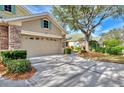 Two car garage with stone accents, shutters, and driveway at 4914 Lakescene Pl, Sarasota, FL 34243