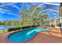 Screened-in pool and spa overlooking lush landscaping and waterfront view at 4914 Lakescene Pl, Sarasota, FL 34243