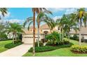 Beautiful home exterior featuring a tile roof, lush landscaping, and a brick driveway at 7244 Orchid Island Pl, Bradenton, FL 34202
