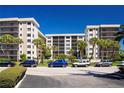 Beautiful condo complex with lush landscaping, palm trees and ample parking on a bright sunny day at 1001 Benjamin Franklin Dr # 110, Sarasota, FL 34236
