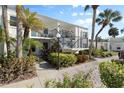 Attractive condo exterior, features a balcony, lush landscaping, and a welcoming entrance at 755 Village Cir # 203, Venice, FL 34292