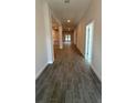 Long hallway with wood-look tile floors and recessed lighting at 2640 Averland Loop, North Port, FL 34287
