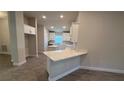 Bright kitchen with white cabinets, quartz countertops, and a central island at 2640 Averland Loop, North Port, FL 34287