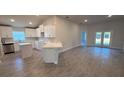 Open-concept kitchen featuring white cabinets, island, and stainless steel appliances at 2640 Averland Loop, North Port, FL 34287