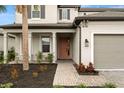 Charming home exterior with a lovely landscaped front yard, paver walkway, and inviting covered porch at 1012 Fernleaf Run, Bradenton, FL 34212