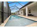 Backyard pool with screened-in enclosure, deck area, and views of the surrounding landscaping at 1012 Fernleaf Run, Bradenton, FL 34212
