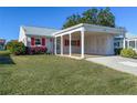 Charming home with a well-maintained lawn, carport, red shutters, and beautiful landscaping at 4714 Potomac Cir, Bradenton, FL 34210