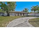 Charming single-story home with a circular driveway and well-manicured lawn, great curb appeal at 5445 Bahia Vista St, Sarasota, FL 34232