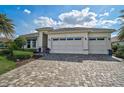 Beautiful home with a spacious three-car garage, meticulously landscaped yard and paver driveway at 8261 Grande Shores Dr, Sarasota, FL 34240
