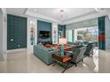 Spacious living room boasts tile floors, stylish decor, and large windows for natural light and a view of the pool at 8261 Grande Shores Dr, Sarasota, FL 34240