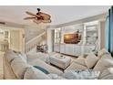 Inviting living room features a decorative ceiling fan, plush sectional sofa, and custom built-in shelving at 5972 Giardino Ln, Sarasota, FL 34232