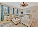 Airy living room with a large sectional sofa, fan, and bright natural light at 5972 Giardino Ln, Sarasota, FL 34232