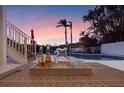 Relaxing poolside view with refreshing drinks and palm trees, perfect for outdoor entertaining at 114 Gull Dr, Anna Maria, FL 34216