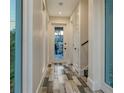 Well-lit hallway featuring luxury vinyl flooring and a glass door entrance to outdoor living space at 1214 Gulf Blvd, Englewood, FL 34223