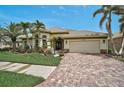 Charming single-story home with lush landscaping, brick driveway, and tile roof, perfect for relaxed living at 1227 Tuscany Blvd, Venice, FL 34292