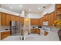 Bright kitchen features tile floors, stainless steel refrigerator, and light wood cabinets at 2773 Harvest Dr, Sarasota, FL 34240